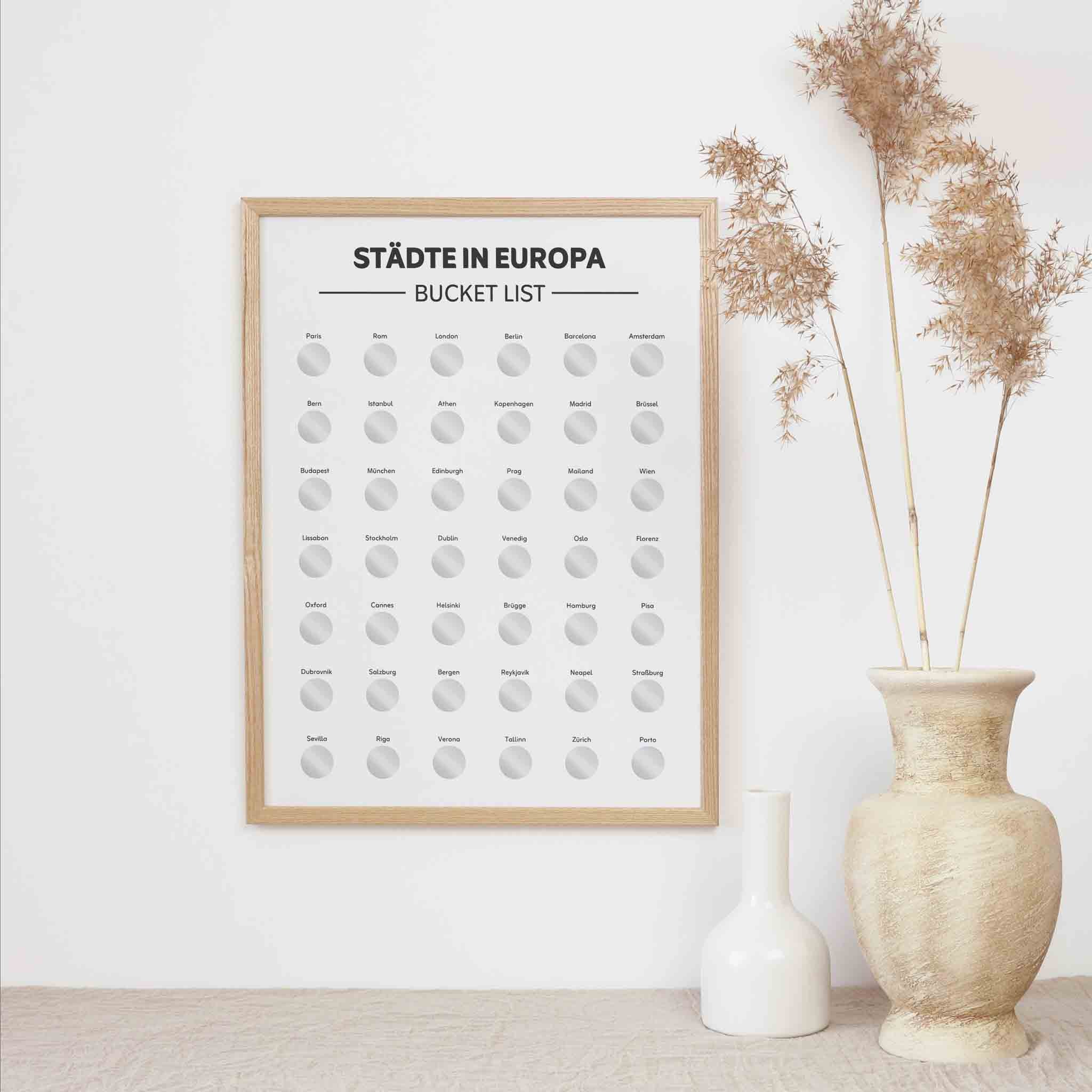 Das funkenschauer Poster Europa A3 - Rubbelkarte mit Städten ist das perfekte Löffelliste Geschenk: Die Europa Karte mit rubbelbaren Städten hängt stilvoll neben beigen Vasen und lädt zum Entdecken neuer Reiseziele ein.