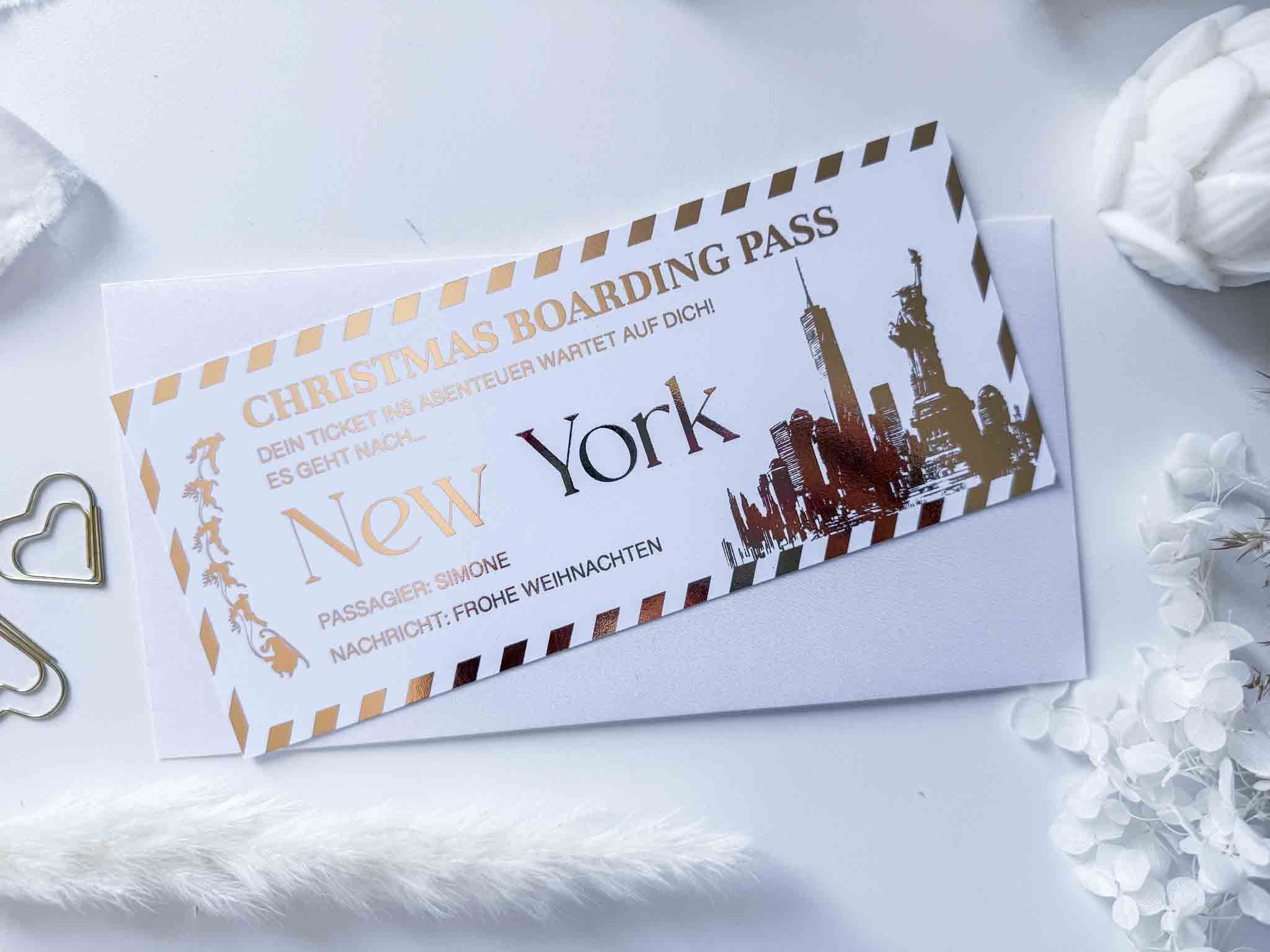 Ein personalisierter funkenschauer Reisegutschein als Weihnachtskarte in Gold-Schwarz-Optik mit festlichem "New York" Motiv, Skyline und deutscher Aufschrift - ideales Geschenk zu Weihnachten im stilvollen Umschlag.