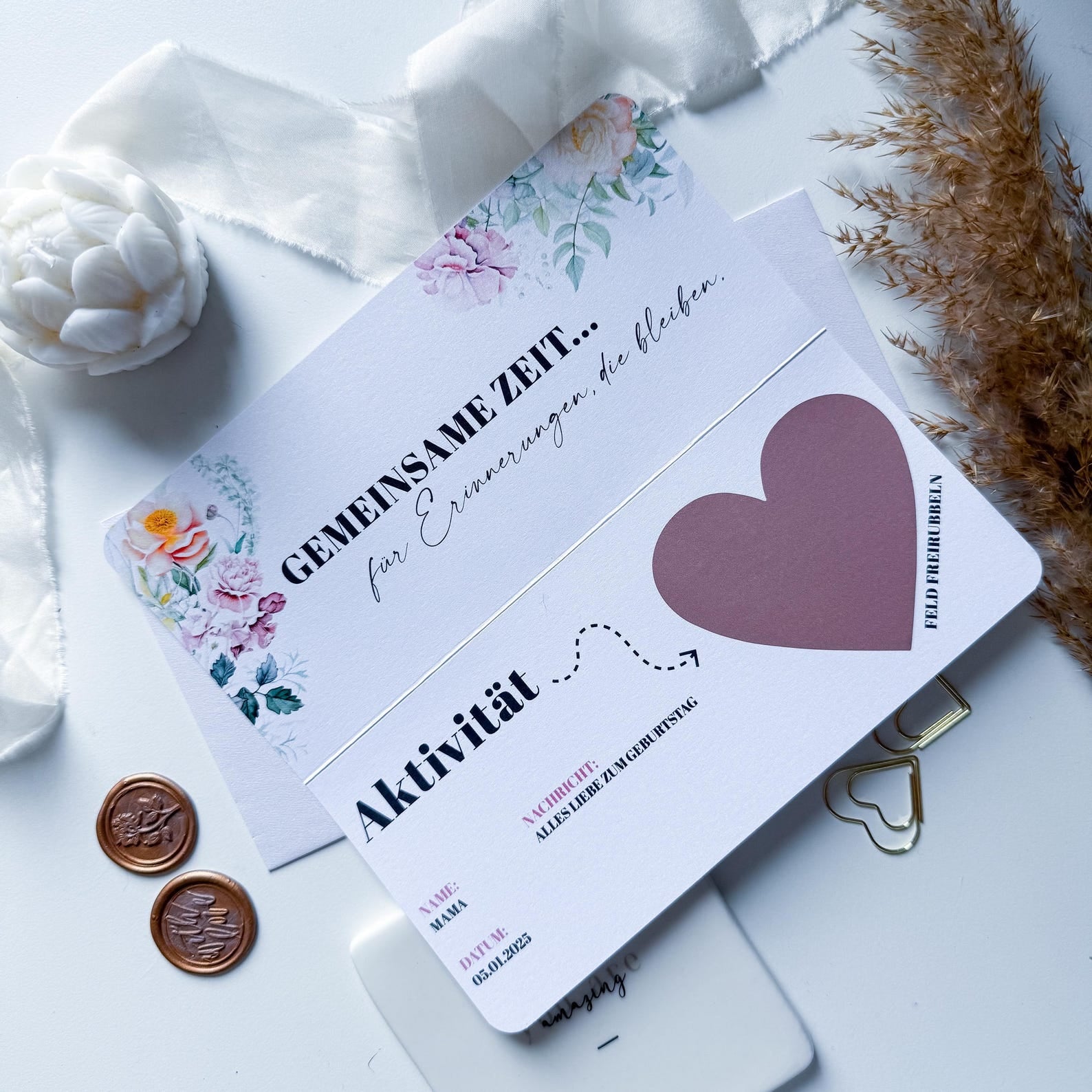 Der funkenschauer "Zeit statt Zeug Gutschein" ist eine florale, personalisierte Rubbelkarte zum Aufklappen - ideal als Geschenk für gemeinsame Zeit - mit lilafarbenem Herz und eleganten Details, die mit Rosen, Pampasgras, Schleifenband, Wachssiegeln und goldenen Büroklammern dargestellt werden.