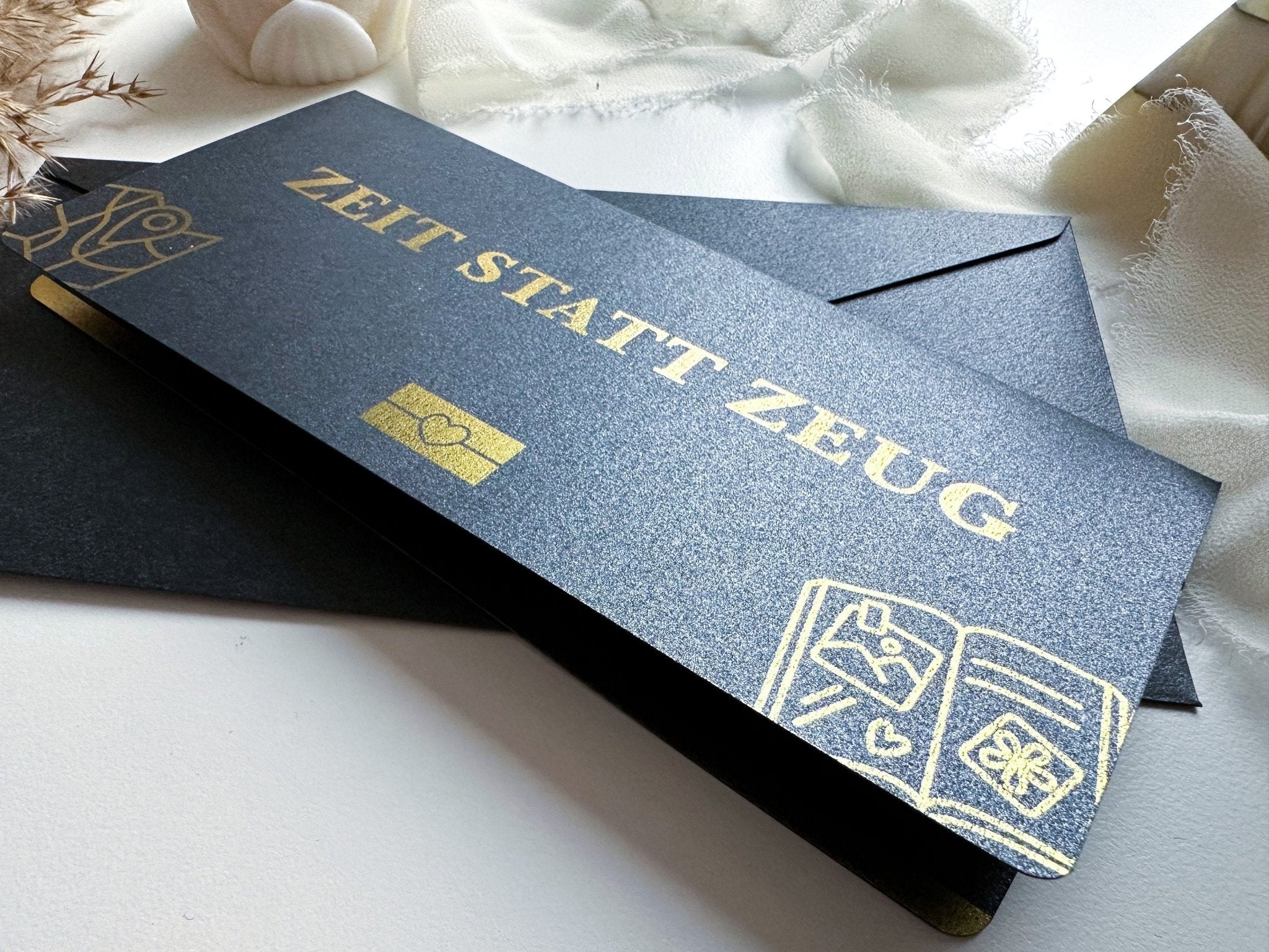 Ein schwarzer, rechteckiger "Zeit statt Zeug Gutschein" von funkenschauer mit goldenen Icons und Text liegt auf einer weißen Fläche. Mit einem Rubbelfeld personalisierbar, ist er die perfekte kreative Geschenkidee für jeden Anlass.