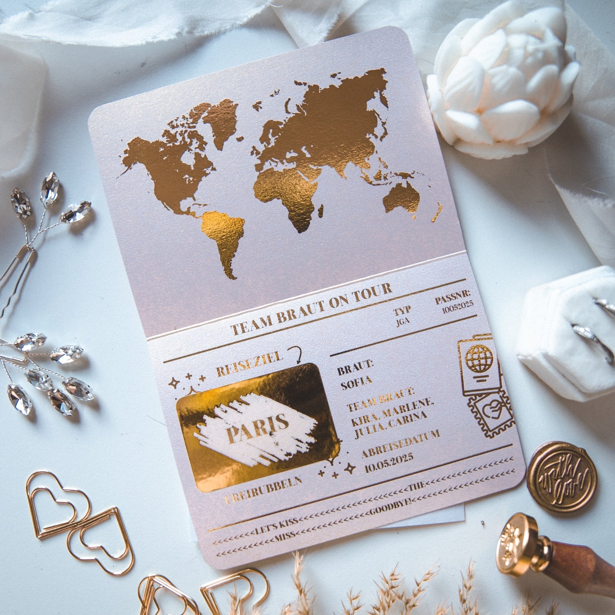 Die funkenschauer Junggesellinnenabschied Ideen Einladung zum JGA verfügt über eine dekorative Karte mit einer goldenen Weltkarte und passähnlichen Details. Es enthält Reisetext, weiße Blumen und eine herzförmige Büroklammer, perfekt für „Team Braut“ auf Tour bei einem Junggesellenabschied.