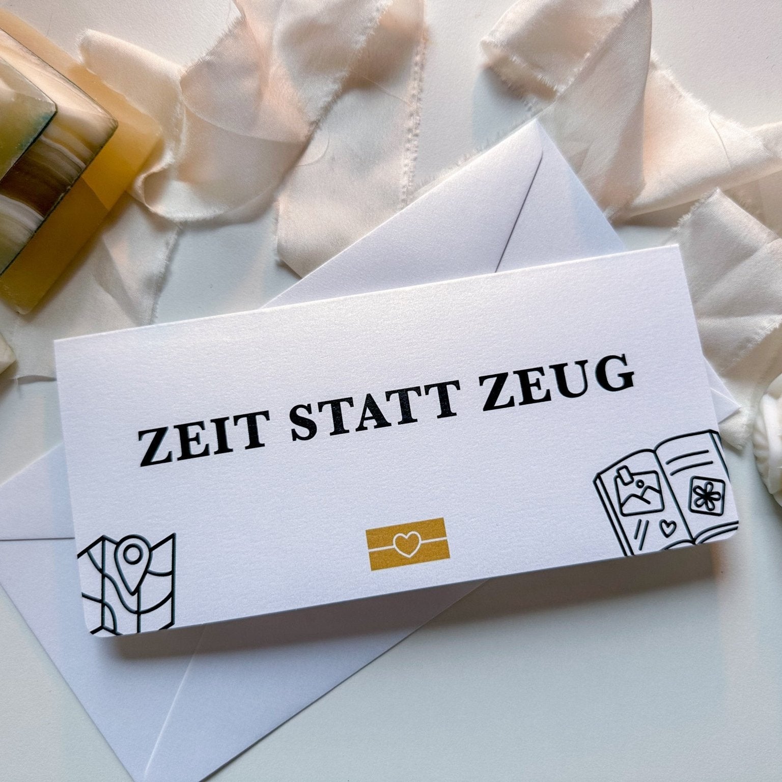 Ein weißer Umschlag von Funkenschauer mit fettem „ZEIT STATT ZEUG“ und einfachen Zeichnungen. Der personalisierbarer Zeit statt Zeug Gutschein (aufklappbar, Rubbelkarte, 17 Farben) – das perfekte Geschenk für gemeinsame Erlebnisse.
