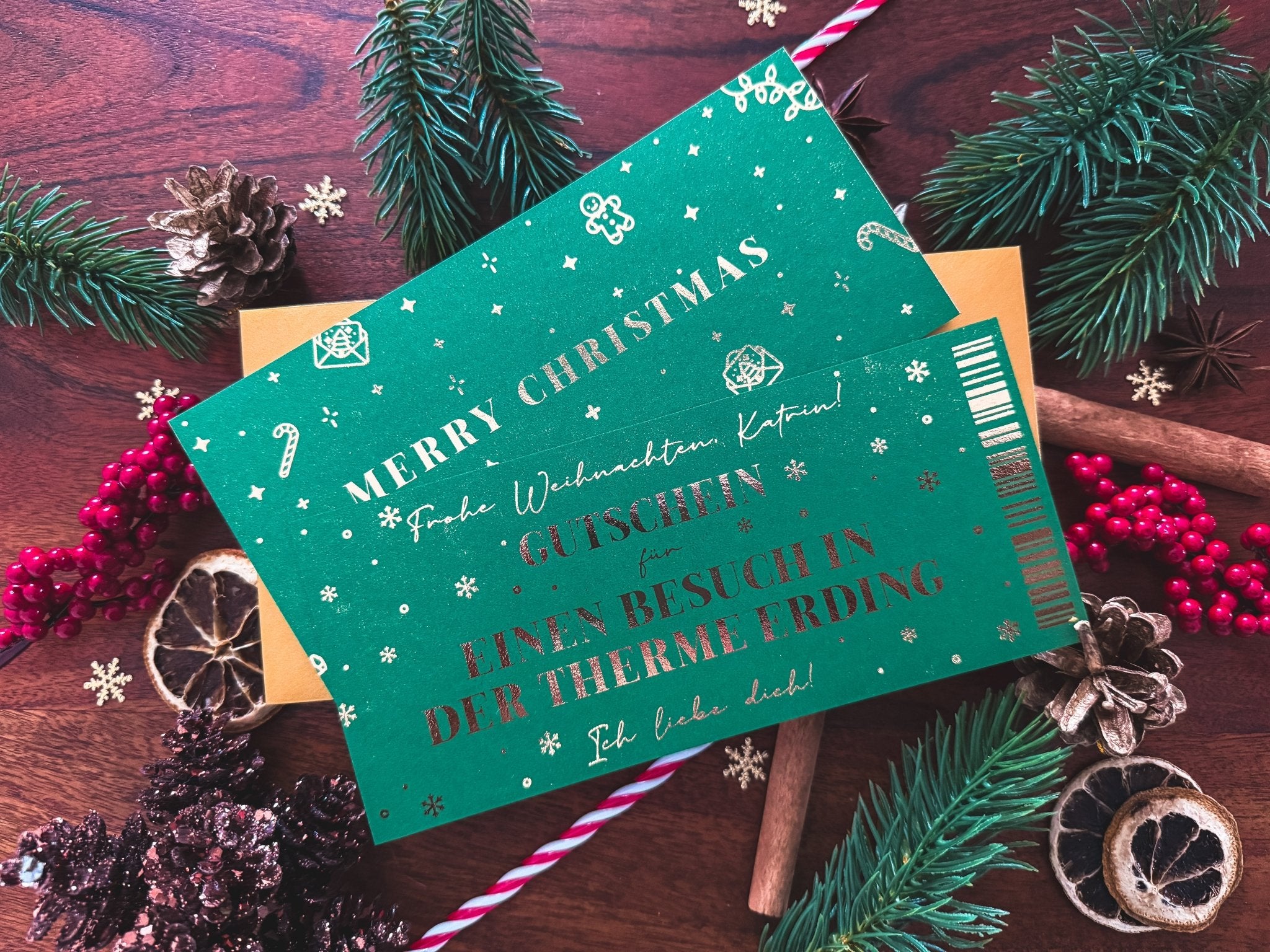 Eine grüne Weihnachtskarte von funkenschauer mit gold-weißer Schrift liegt festlich dekoriert - perfekt für persönliche Weihnachtsgeschenke: den personalisierbaren Gutschein "Zeit statt Zeug" als Rubbelkarte, die individuelle Geschenkidee zum Fest!.