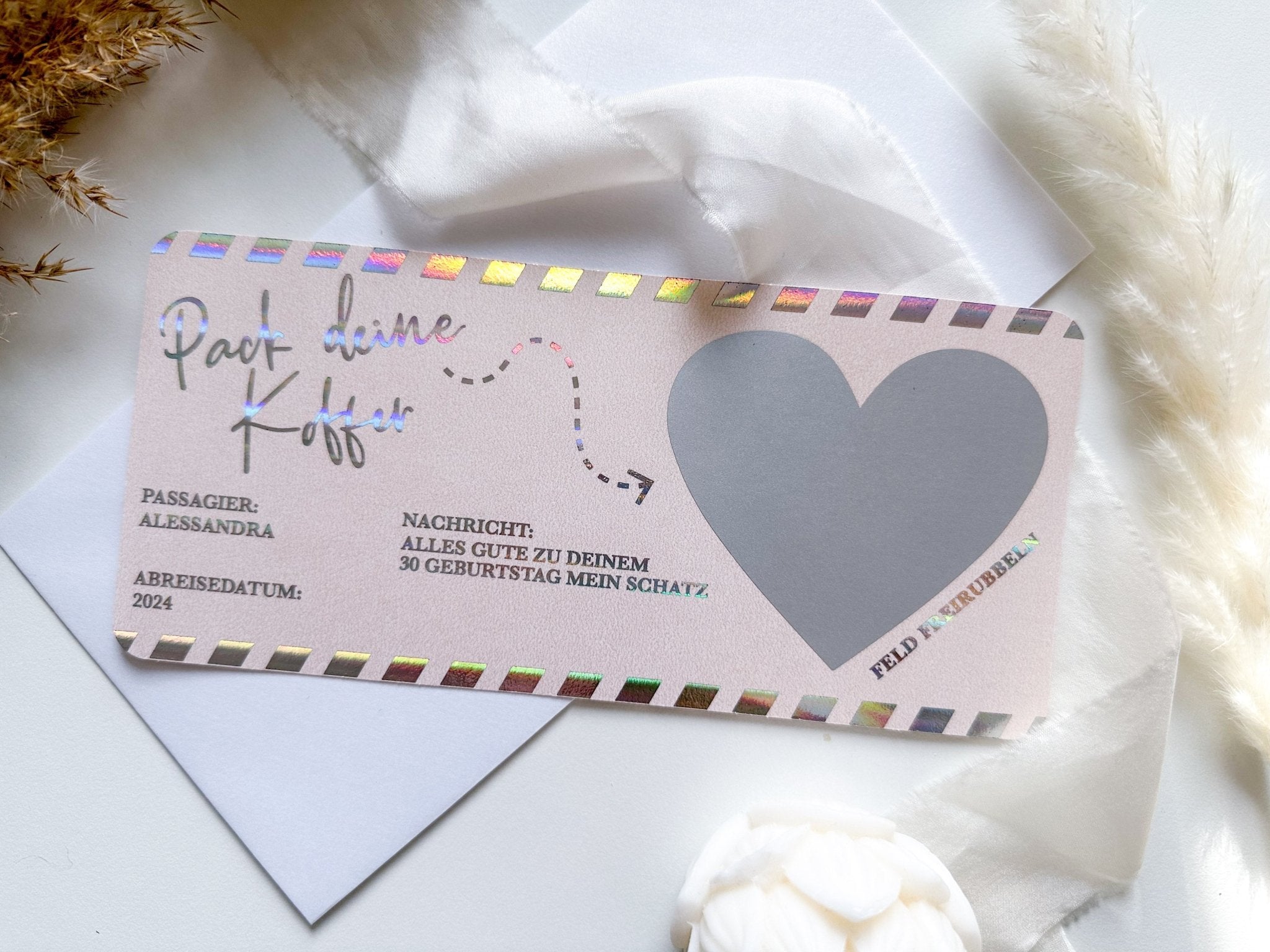 Der Funkenschauer Reisegutschein zum Verschenken verfügt über ein pastellfarbenes Design, einen stempelähnlichen Rand, den Text „Pack deinen Koffer“ und ein graues Herz-Nachrichtenfeld. Getrocknete Gräser und eine weiße Blume werten diese elegante Geschenkidee für Reiseliebhaber auf.