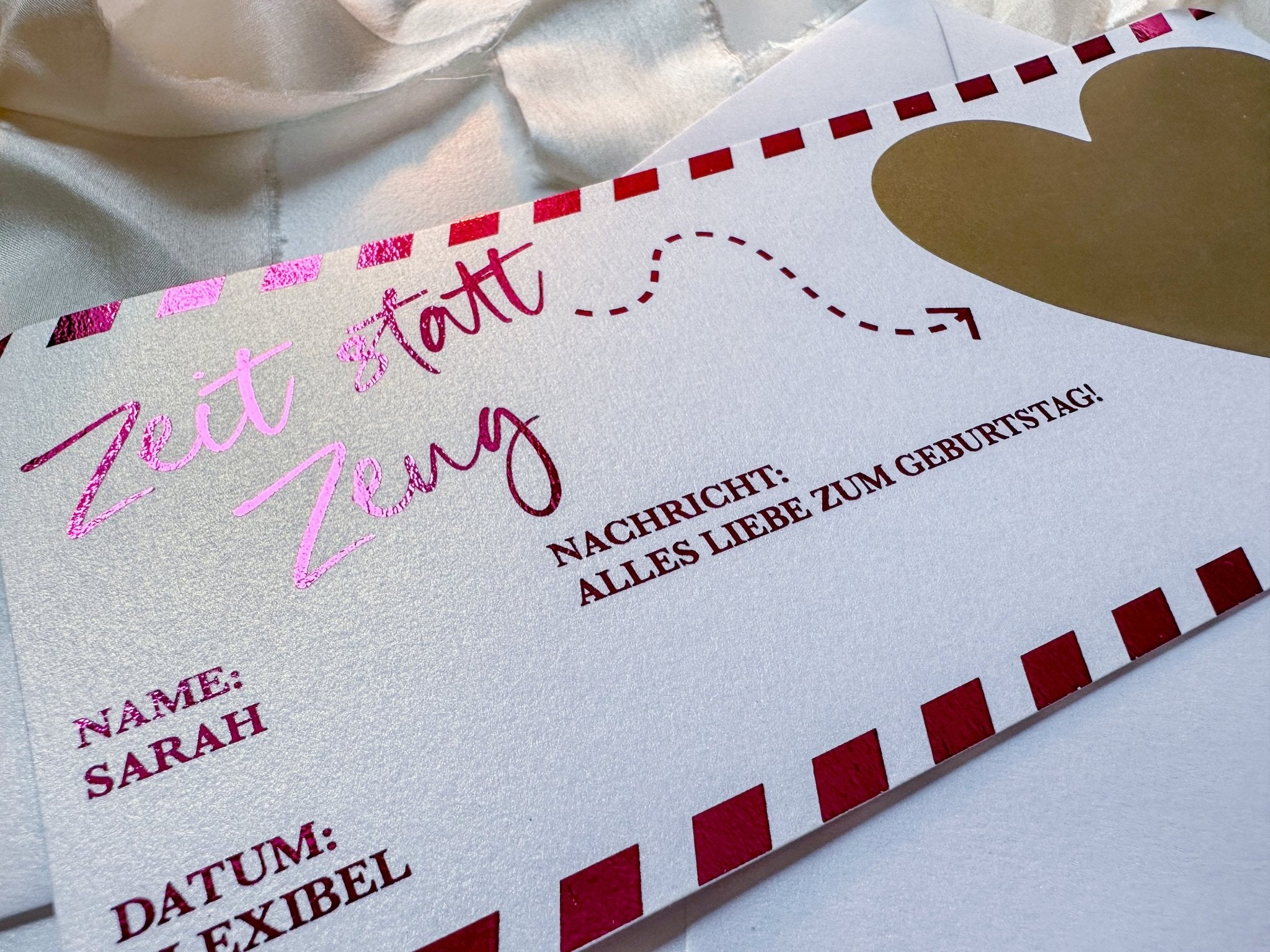 Der elegante Gutschein „Zeit statt Zeug“ von funkenschauer besticht durch seine rosa Schreibschrift, ein großes goldenes Herz und einen roten Rand. Er ist ideal für alle, die Erlebnisse schätzen. Personalisieren Sie ihn mit einer Nachricht, einem Namen wie „Sarah“ und wählen Sie „Datum: Flexibel“.