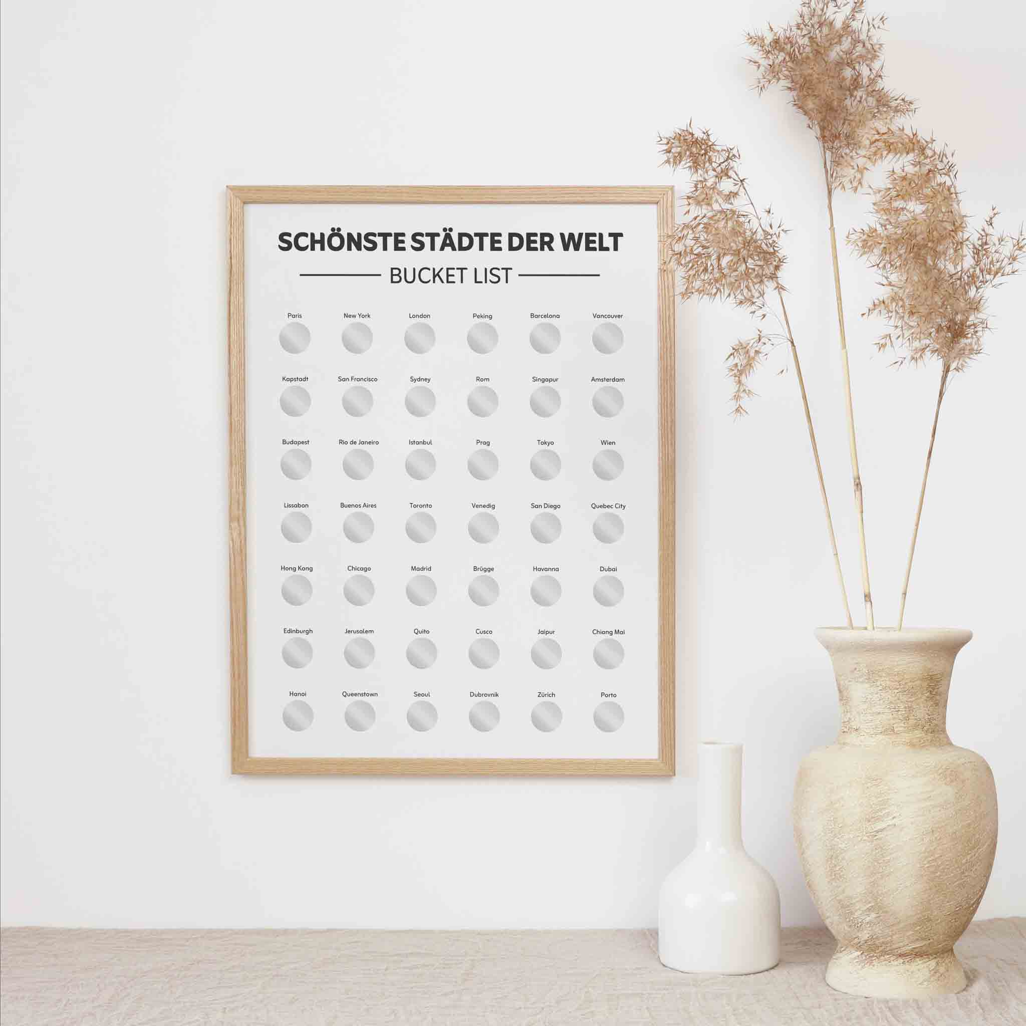 Das funkenschauer Poster "Schönste Städte der Welt Bucketlist zum Freirubbeln" (A3) hängt neben Trockenblumenvasen. Es zeigt eine Löffelliste berühmter Städte mit freirubbelbaren Feldern - das perfekte Reise-Geschenk zu Weihnachten.