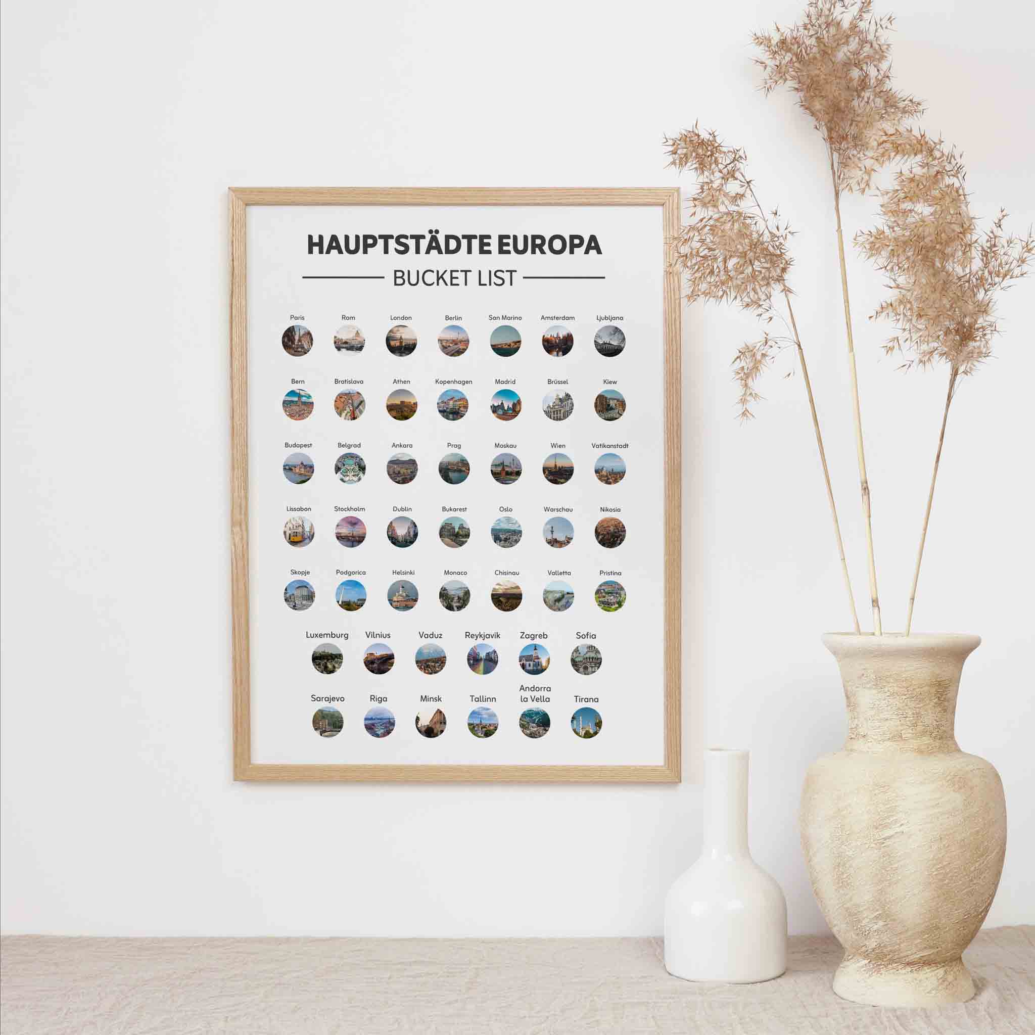 Das funkenschauer "Hauptstädte Europas Bucketlist zum Freirubbeln" Rubbelposter ist ein stilvolles Reisegeschenk, das Fotos von europäischen Hauptstädten zeigt und als Wandkunst neben dekorativen Vasen mit getrocknetem Gras steht.