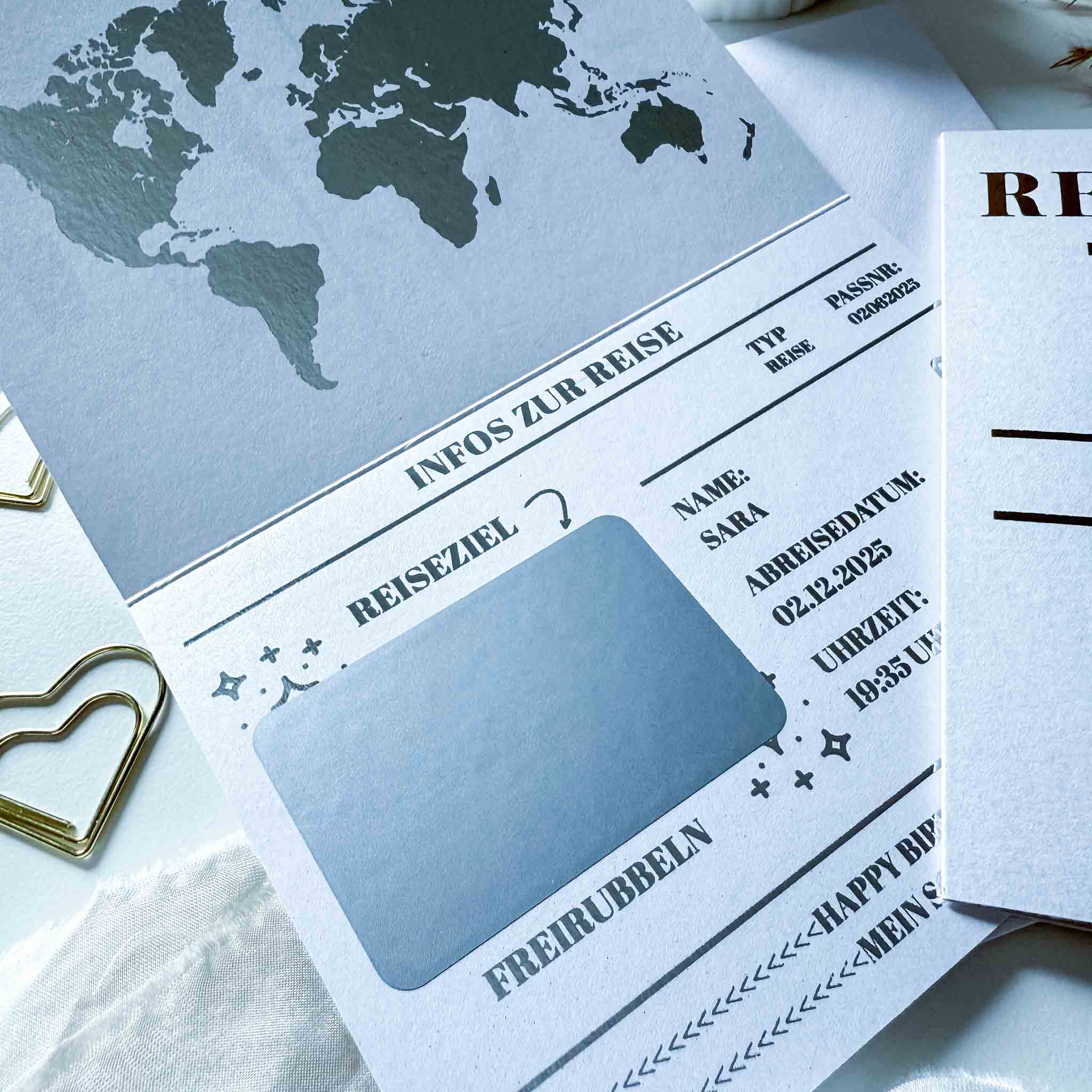 Eine Nahaufnahme des funkenschauer Personalisierten Reisepasses als Rubbelkarte mit Weltkarte und deutschen Textfeldern für Reisedaten - ideal als Geburtstagsgeschenk, personalisierter Reisegutschein oder Gutschein verschenken, inklusive Umschlag.