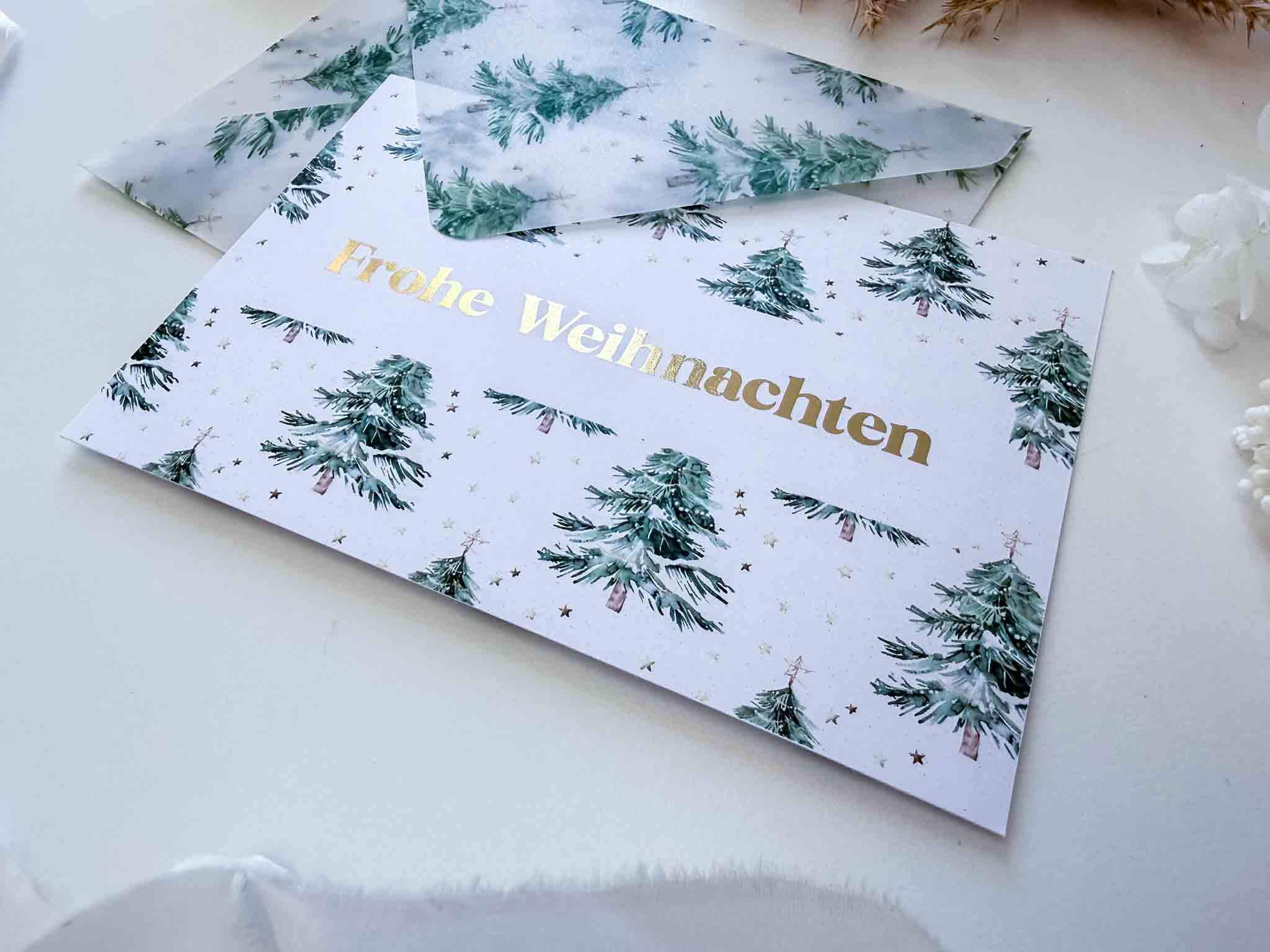 Der "Reisegutschein Weihnachten" von funkenschauer ist eine Rubbelkarte mit grünem Tannenbaum- und Goldstern-Design sowie "Frohe Weihnachten"-Schrift in Gold. Ideal als Geschenk für Weltenbummler, inkl. handgemachtem Umschlag.