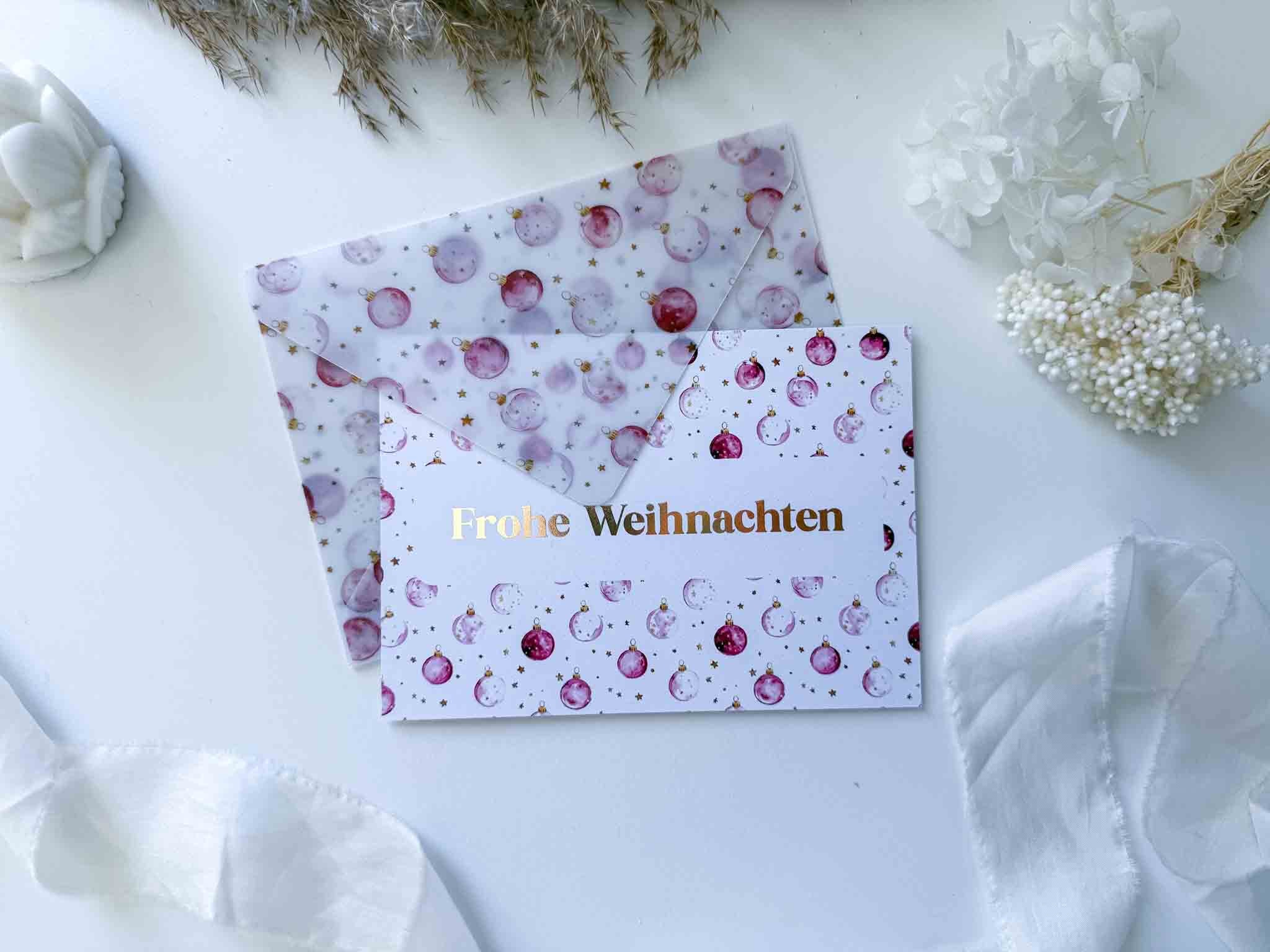 Eine funkenschauer Weihnachten Gutschein Zeit statt Zeug Rubbelkarte mit handgemachtem Umschlag liegt auf weißem Untergrund, teils im passenden Umschlag, umgeben von Winterdeko, Trockenblumen und festlichen Ornamenten.