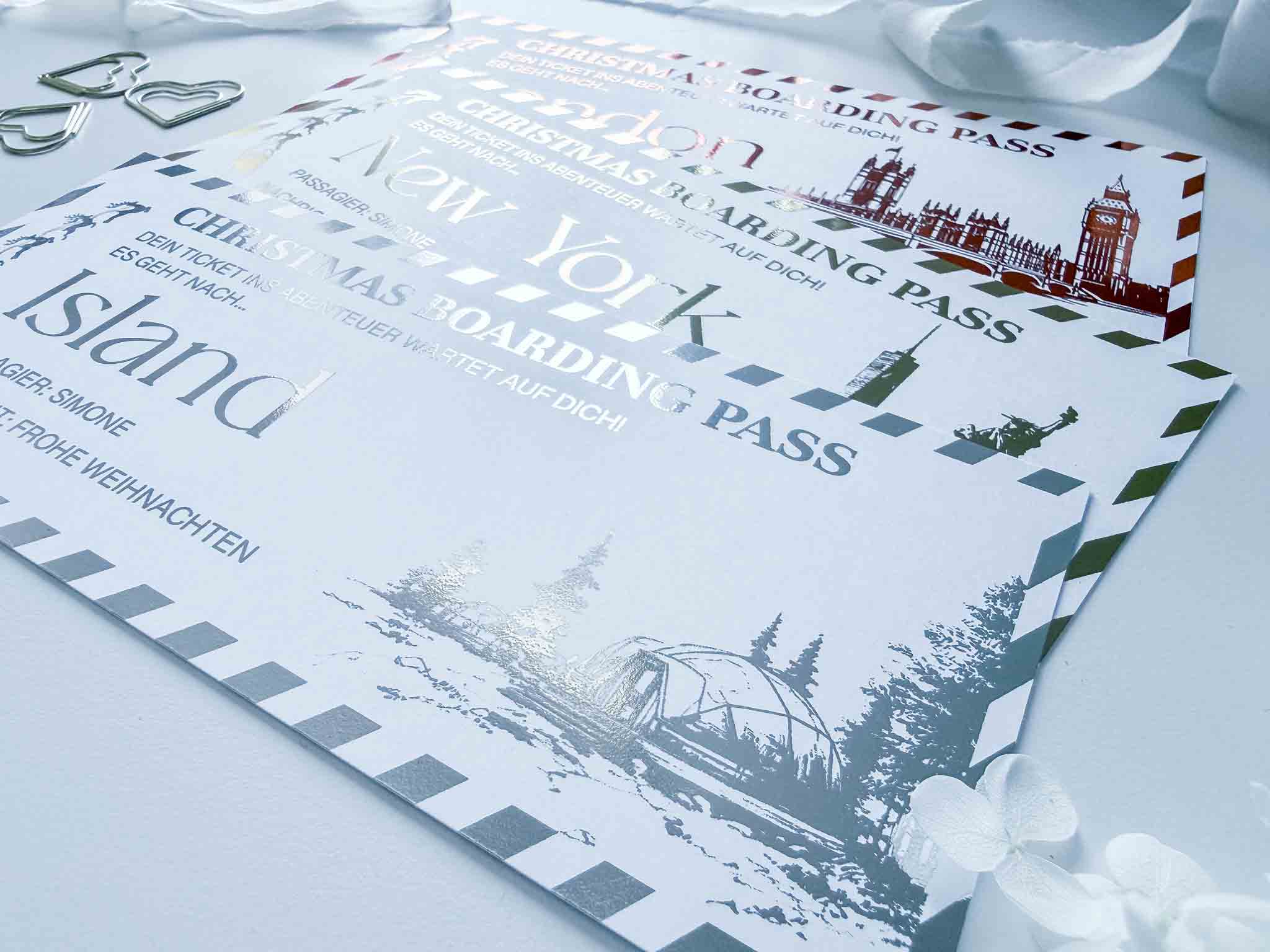 Drei festliche funkenschauer Reisegutscheine Weihnachtsgutschein Bordkarten für London, New York und Island zeichnen sich durch fröhliche Designs aus - perfekt als personalisierte Gutscheine für Weihnachten oder als Weihnachtsgeschenk. Schleifen- und Herzdetails sorgen für weihnachtlichen Charme.
